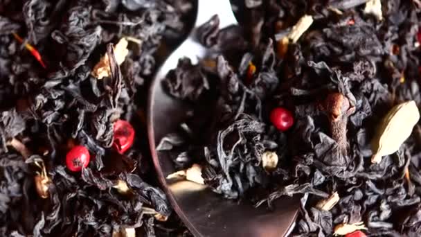 Black tea with berries, close-up of tea in a spoon. — Stock Video