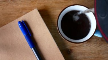 Bir fincan kahve ve bir defter bir kalem ile. Freelancing kavramı.