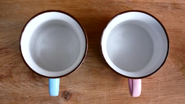 Dos tazas, una añadir café a otro té . — Vídeos de Stock