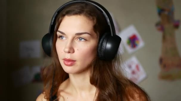 Primer plano de la hermosa mujer joven escuchando música en los auriculares — Vídeos de Stock