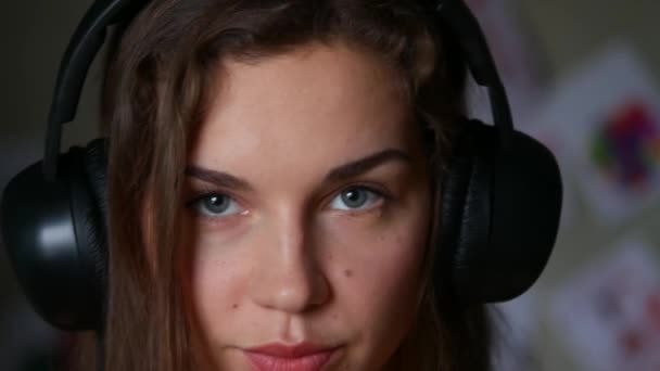 Primer plano de la hermosa mujer joven escuchando música en los auriculares — Vídeo de stock