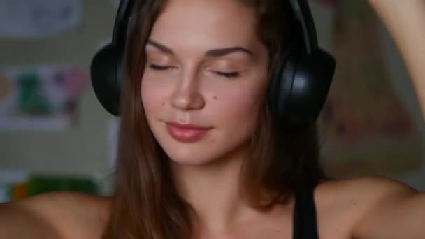Primer plano de la hermosa mujer joven escuchando música en los auriculares — Vídeos de Stock