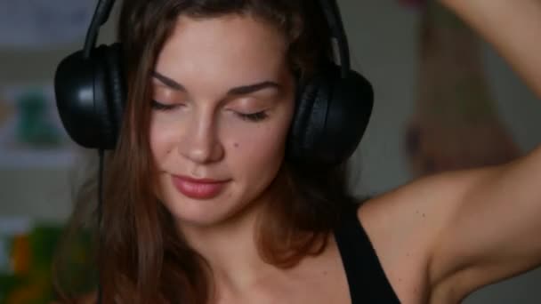 Primer plano de la hermosa mujer joven escuchando música en los auriculares — Vídeos de Stock