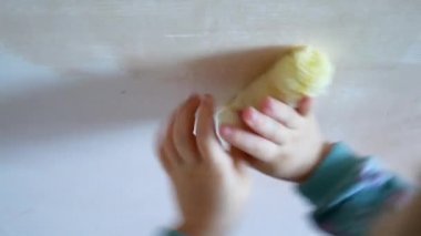 Kız onun odasına onarım yapmak için yardımcı olur. Çocuk bir rulo duvar boyaları.