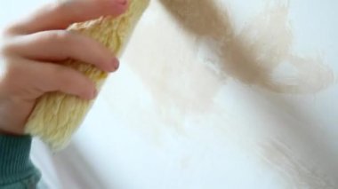 Kız onun odasına onarım yapmak için yardımcı olur. Çocuk bir rulo duvar boyaları.