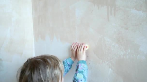 Het meisje helpt bij het doen van reparaties in haar kamer. Het kind schildert de muren met een roller. — Stockvideo