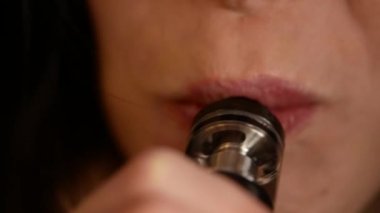 Güzel kadın elektronik sigara içiyor ve duman bulutları yapar, teen vaping, e-cig ve vape kalem, insanların kötü alışkanlıkları
