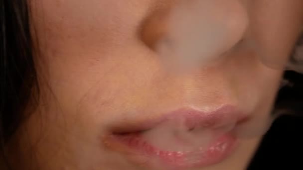 Gros plan sur la femme qui fume. La fille libère lentement et sexuellement de la fumée d'une cigarette électronique — Video