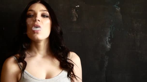 Κοντινό πλάνο γυναίκα το κάπνισμα. Το κορίτσι σιγά-σιγά και σεξουαλικά απελευθερώνει καπνός από ένα ηλεκτρονικό τσιγάρο — Αρχείο Βίντεο