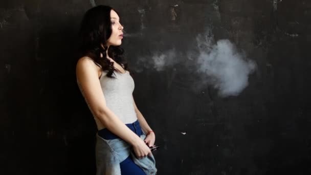 Κοντινό πλάνο γυναίκα το κάπνισμα. Το κορίτσι σιγά-σιγά και σεξουαλικά απελευθερώνει καπνός από ένα ηλεκτρονικό τσιγάρο — Αρχείο Βίντεο