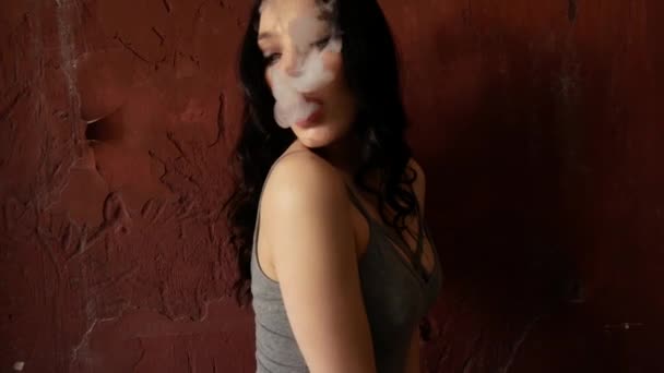 Gros plan sur la femme qui fume. La fille libère lentement et sexuellement de la fumée d'une cigarette électronique — Video