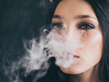 kadın siyah arka plan üzerine bir sigara