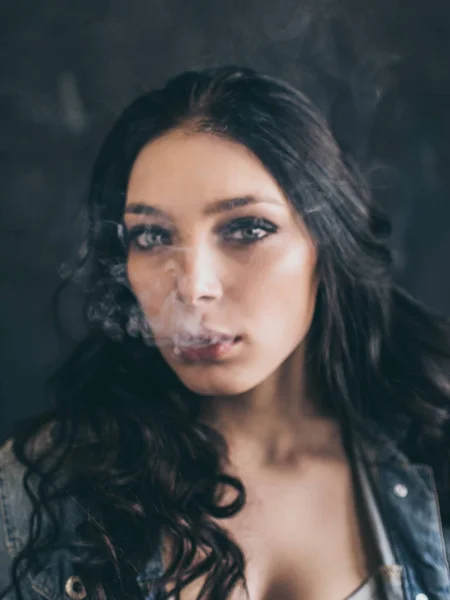Donna che fuma una sigaretta su sfondo nero — Foto Stock