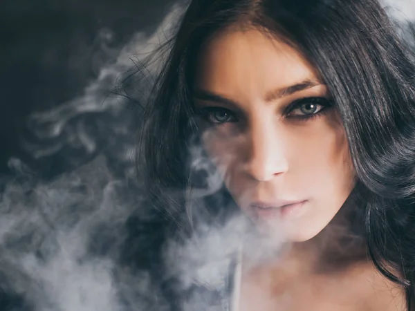 Frau raucht Zigarette auf schwarzem Hintergrund — Stockfoto