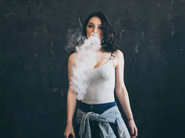 Femme fumant une cigarette sur fond noir — Photo