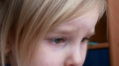 Anne saçı yaparken küçük bir kız hevesle telefonda bir çizgi film izliyor.