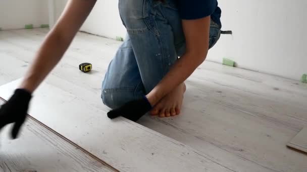 自宅で修理。男は、積層の床を敷設します。. — ストック動画