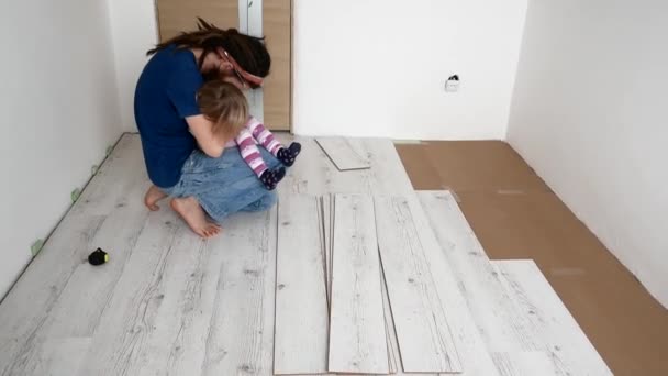 Папа и дочь делают ремонт в квартире. Укладка ламината — стоковое видео