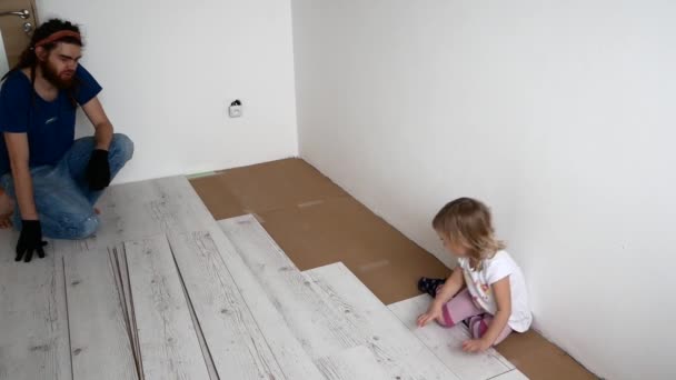Dad and daughter are doing repairs in the apartment. Laminate laying — Stock Footage Dad and daughter are doing repairs in the apartment. Laminate laying Royalty Free Stock Footage