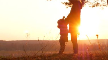 Anne ve bebek günbatımı siluetleri