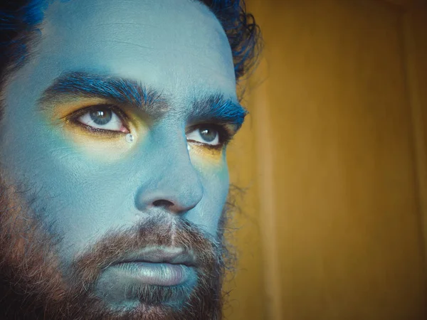 Portret mężczyzny z niebieskim makijażu na twarzy. Etapie makijaż, jak obcy, fantasy. — Zdjęcie stockowe