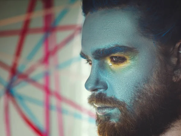 Porträtt av en man med en blå sminkning på hans ansikte. Skede make-up, som en utomjording, fantasy. — Stockfoto