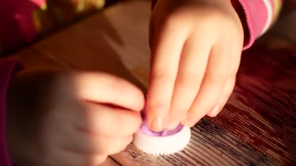 Unknown little girl sitting at the desk sculpts a different figures from made of colored modeling plasticine in the nursery — Stock Video