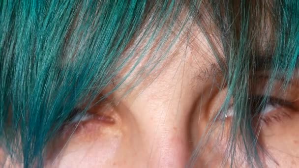 Zbliżenie: kobiece oczy. Zielone włosy przed oczami — Wideo stockowe