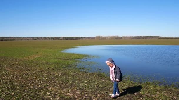 Una bambina cammina vicino al lago in primavera — Video Stock