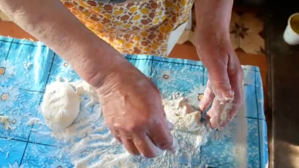 Стара бабуся замішує тісто на столі. 4-кілометровий — стокове відео
