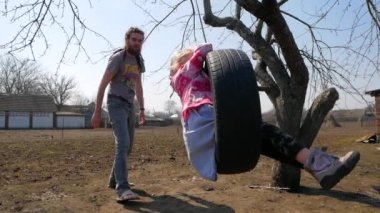 Babası kızını parkta eğlenceli görürken salıncak iterek