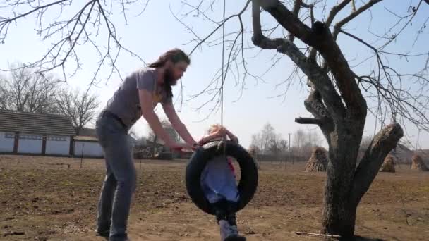 Vader dochter duwen op de schommel terwijl je plezier in het park — Stockvideo