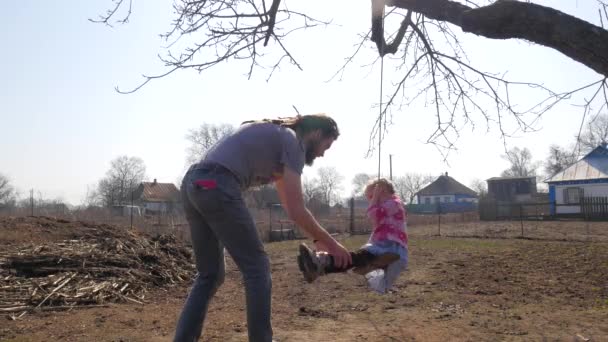 Babası kızını parkta eğlenceli görürken salıncak iterek — Stok video