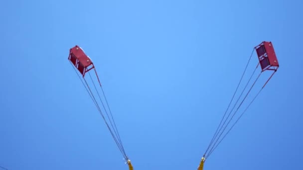 Karussell wirbelt gegen den blauen Himmel — Stockvideo