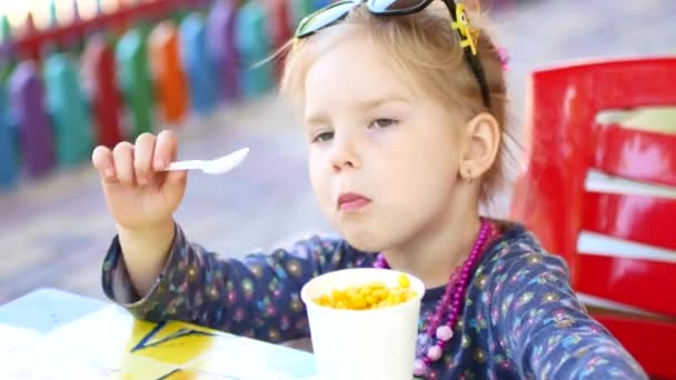 Menina comendo comida de rua milho no parque de verão, conceito de comida de viagem — Vídeo de Stock