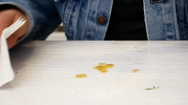 Uma mulher limpa uma mesa com gotas de molho com um guardanapo — Vídeo de Stock