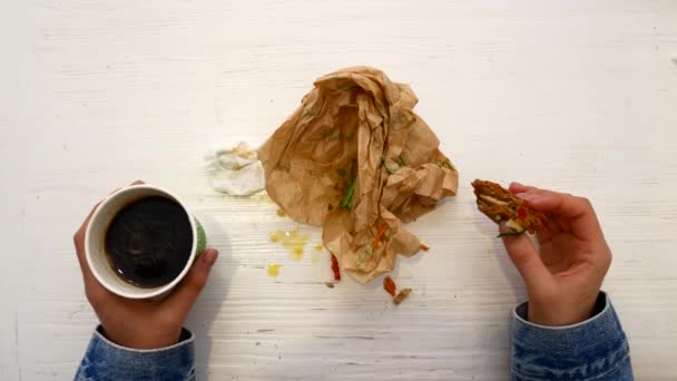 Vrouw eten boterham, zithoek in de buurt van het venster in het café — Stockvideo