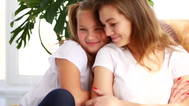 Mother and daughter communicate sitting at home on the couch. Daughter shares her experiences, and mom hugs and cares — Stock Video