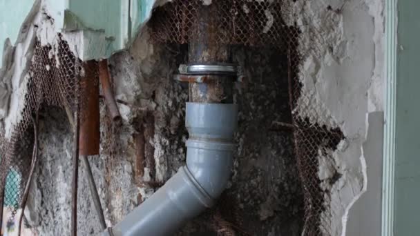 Alcantarillado viejo en una casa en reparación. Tubos de plástico para el agua en una pared rota — Vídeos de Stock