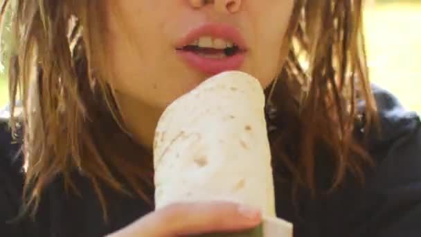 Uma jovem garota brinca e canta uma música em shawarma como um microfone. Mulher cantando em kebab — Vídeo de Stock