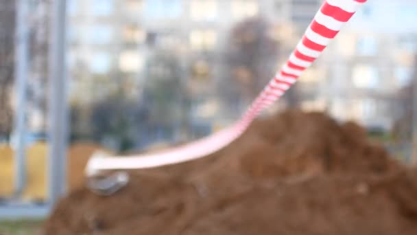 Red-white striped ribbon. The fencing of the repair site or the crime scene — Stock Video