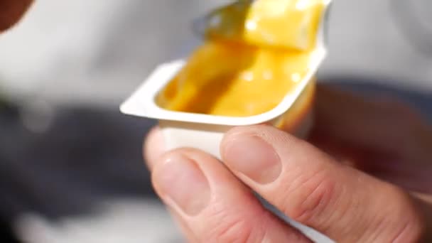 A man dips french fries in mustard sauce. Close-up of jars of sauce and potatoes — Stock Video