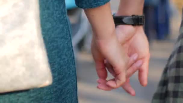 Una pareja se coge de la mano. Un chico y una chica están caminando, tienen una cita romántica — Vídeos de Stock