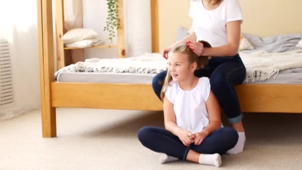 Mamãe faz suas filhas penteado. Mãe e filha estão se preparando para ir para a escola — Vídeo de Stock