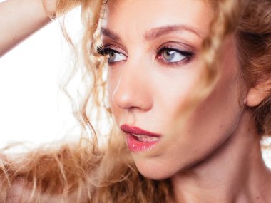 Kıvırcık saçlı güzel bir kızın portresi. Beyaz bir arka planda duygusal neşeli bir kadın..