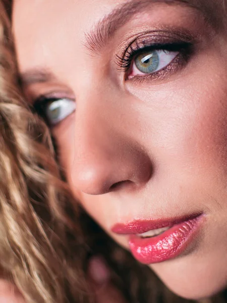 Portrait of a young beautiful woman. Girl against a dark background with a natural smile and curly hair. — Stock Photo, Image