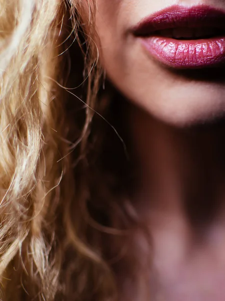 Portret van een mooie jonge vrouw. Meisje tegen een donkere achtergrond met een natuurlijke glimlach en krullend haar. — Stockfoto