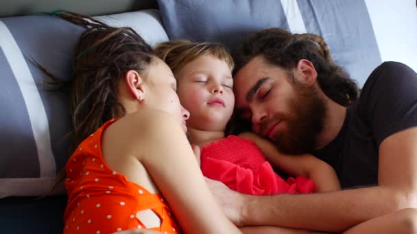 Familia con un niño durmiendo en la cama. Dormir durante el día con toda la familia — Vídeo de stock