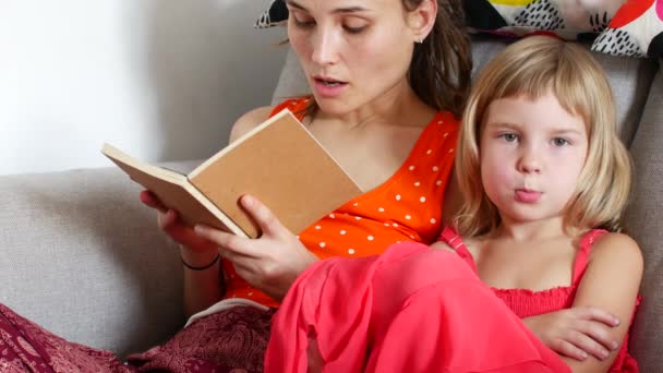 Mam leest een boek voor aan haar dochter — Stockvideo