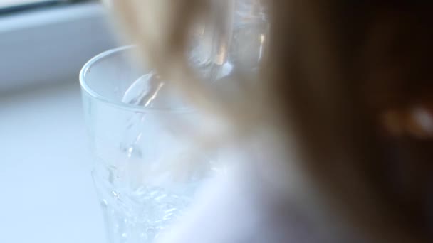 A child pours water from a jug into a glass — 图库视频影像